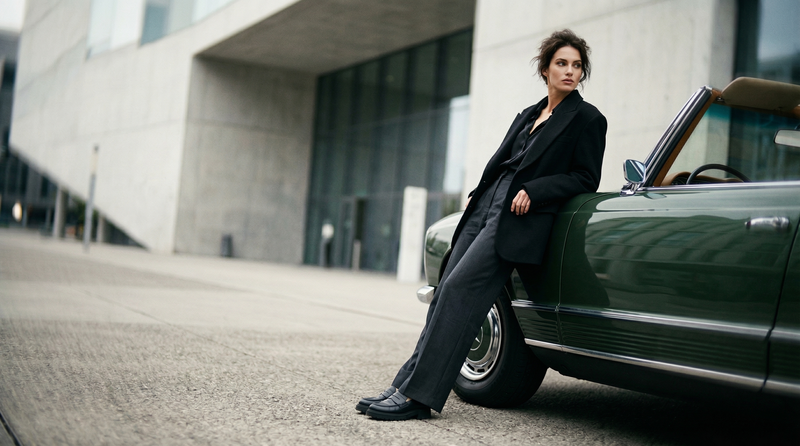 A woman leaning on a vintage car